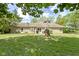 Well-kept backyard featuring a beautiful stone house, lush lawn, and lovely mature trees at 2315 Elm Swamp Rd, Lebanon, IN 46052