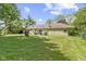 Lush backyard with a stone house, large trees, and a well-maintained lawn for outdoor activities at 2315 Elm Swamp Rd, Lebanon, IN 46052