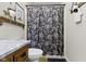 Cozy bathroom with a floral shower curtain, a marble countertop, and gray tile flooring at 2315 Elm Swamp Rd, Lebanon, IN 46052