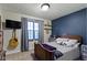 Cozy bedroom with a navy accent wall, wooden headboard, and guitar accent for a personalized touch at 2315 Elm Swamp Rd, Lebanon, IN 46052