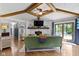 Inviting living room featuring wood floors, a stone fireplace, wood beams and a sliding glass door to the yard at 2315 Elm Swamp Rd, Lebanon, IN 46052