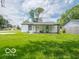 View of the home's backyard featuring covered patio and green grass at 3101 Gerrard Ave, Indianapolis, IN 46224