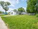 A well-manicured front yard with a single-story home featuring a black roof and white siding at 3101 Gerrard Ave, Indianapolis, IN 46224