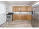 Bright kitchen with laminate floor, wooden cabinets and modern appliances at 3101 Gerrard Ave, Indianapolis, IN 46224