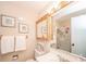 Bathroom with wooden framed mirror, towels, sink, toilet, medicine cabinet and glass shower door at 317 Stoner Dr, Anderson, IN 46013