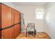 Bedroom with wood floors, tan walls, a chair, a single window, wardrobe with several cabinets, and rolled up carpet at 317 Stoner Dr, Anderson, IN 46013