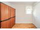 Bright bedroom with tan walls, wood floors, a single window and wardrobe with several cabinets at 317 Stoner Dr, Anderson, IN 46013