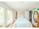 Bright bedroom featuring hardwood floors, a double door to a porch, a floral patterned bed, and a ceiling fan at 317 Stoner Dr, Anderson, IN 46013