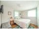 Cozy bedroom featuring a floral-patterned bed, two windows, a blue and green rug, and a TV at 317 Stoner Dr, Anderson, IN 46013