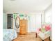 Bedroom with hardwood floors, floral patterned bed, a colourful patchwork chair, and a wooden dresser with a mirror at 317 Stoner Dr, Anderson, IN 46013