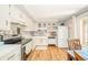 Open kitchen with white cabinets, stainless steel appliances, and wood flooring offers a lot of light and space at 317 Stoner Dr, Anderson, IN 46013