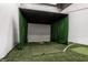 Indoor golf simulator with putting green, golf club, and a black projection screen at 350 N Meridian St # 606/607, Indianapolis, IN 46204