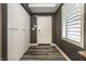 Hallway with gray walls, modern wood floors, white door, and a shuttered window at 350 N Meridian St # 606/607, Indianapolis, IN 46204