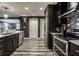 Modern kitchen featuring dark cabinetry, stainless steel appliances and hardware, and plank floors at 350 N Meridian St # 606/607, Indianapolis, IN 46204