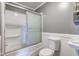 Bathroom featuring a tub-shower with sliding glass doors, toilet, and sink at 3513 Ireland Dr, Indianapolis, IN 46235