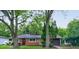 Cozy one-story home with a dark-shingled roof, dark-colored front door, and an attached garage surrounded by mature trees at 3513 Ireland Dr, Indianapolis, IN 46235