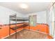 A bedroom with a bunk bed, an orange accent wall and a bright window at 3515 Lindenwald Dr, Indianapolis, IN 46217