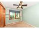 A light blue bedroom featuring a window, a ceiling fan and a built in bookshelf at 3515 Lindenwald Dr, Indianapolis, IN 46217