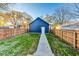 Spacious backyard with lush grass, wooden fence, and a detached garage, perfect for outdoor activities at 430 N Keystone Ave, Indianapolis, IN 46201