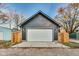 Detached garage with a white door, gray siding, and flanked by wooden fences at 430 N Keystone Ave, Indianapolis, IN 46201
