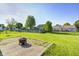 This grassy backyard has a concrete patio with a metal fire pit at 431 Alton Dr, Greenwood, IN 46143