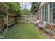 Cozy backyard featuring a small lawn area, seating, shade structure, and lush greenery at 4901 N Kenwood Ave, Indianapolis, IN 46208