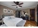 Comfortable bedroom with hardwood floors, a decorative ceiling fan, and moody dark furniture at 4901 N Kenwood Ave, Indianapolis, IN 46208