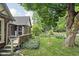 Side view of a bungalow with a brick exterior, fenced yard and mature tree at 4901 N Kenwood Ave, Indianapolis, IN 46208