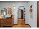 Inviting hallway featuring arched doorways, vintage decor, hardwood floors, and blue accent walls at 4901 N Kenwood Ave, Indianapolis, IN 46208