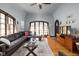 Comfortable living room featuring hardwood floors, a large window, and a brown leather sofa at 4901 N Kenwood Ave, Indianapolis, IN 46208
