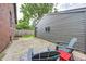 Backyard patio with gray wood chairs and table, next to the garage at 5144 N College Ave, Indianapolis, IN 46205