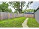Backyard view showcasing a large green lawn with a wooden privacy fence at 5144 N College Ave, Indianapolis, IN 46205
