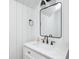 Modern bathroom vanity features a black-framed mirror and wall sconces at 5144 N College Ave, Indianapolis, IN 46205