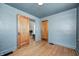 Bedroom featuring hardwood floors, and light-blue painted walls, plus two doors to nearby rooms at 5144 N College Ave, Indianapolis, IN 46205