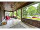 Relaxing covered porch with brick accents, tile flooring, and neighborhood views at 5144 N College Ave, Indianapolis, IN 46205