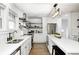 Bright kitchen with stainless steel appliances, floating shelves and modern lighting at 5144 N College Ave, Indianapolis, IN 46205