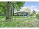 Spacious backyard with a lush green lawn, mature trees, and a cozy patio area for outdoor enjoyment at 5530 Pilgrim Dr, Indianapolis, IN 46254