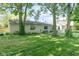 Wide backyard featuring lush greenery, mature shade trees, and a patio area for relaxation and entertainment at 5530 Pilgrim Dr, Indianapolis, IN 46254