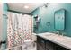 Stylish teal bathroom featuring a chic vanity, modern fixtures, and a shower with a playful polka dot curtain at 5530 Pilgrim Dr, Indianapolis, IN 46254