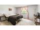 Neutral-toned bedroom featuring a full-size bed, plush carpeting, and a window with patterned curtains at 5530 Pilgrim Dr, Indianapolis, IN 46254