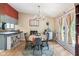 Cozy dining area with stylish lighting, wood floors, colorful accents, and seamless flow into the kitchen at 5530 Pilgrim Dr, Indianapolis, IN 46254