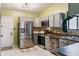 Galley kitchen featuring stainless steel appliances, tiled backsplash, and painted gray cabinets at 5530 Pilgrim Dr, Indianapolis, IN 46254