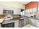 Bright eat-in kitchen featuring gray cabinets, tiled backsplash, stainless appliances and an adjacent dining area at 5530 Pilgrim Dr, Indianapolis, IN 46254