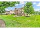 Expansive backyard with lush lawn, mature trees, landscaping, deck and fire pit area perfect for outdoor activities at 5865 Osage Dr, Carmel, IN 46033