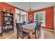 Elegant dining room with bright orange accent walls and decor near open entryway and built-in at 5865 Osage Dr, Carmel, IN 46033