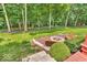 Backyard featuring a stone fire pit area with built-in bench seating and professional landscaping at 5865 Osage Dr, Carmel, IN 46033