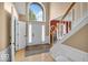 Bright foyer features a large arched window, white staircase and wood-look flooring at 5865 Osage Dr, Carmel, IN 46033
