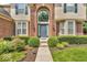 Close up view of a home's stately brick facade, arched entryway, and well-kept landscaping at 5865 Osage Dr, Carmel, IN 46033