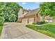 Charming home showcasing manicured lawn, mature trees, long driveway, and three-car garage at 5865 Osage Dr, Carmel, IN 46033