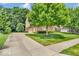 Charming home showcasing manicured lawn, mature trees, long driveway, and three-car garage at 5865 Osage Dr, Carmel, IN 46033
